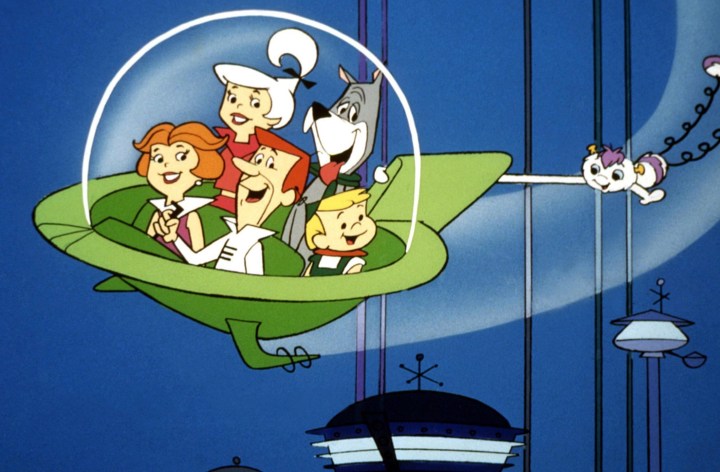 The Jetsons family flying in a green flying car with a futuristic city skyline in the background.