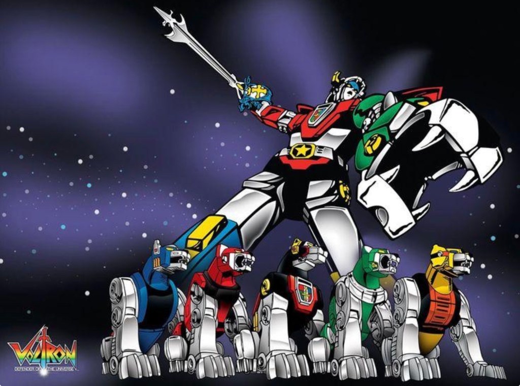 A group of colorful robotic lions forming Voltron, with the main robot standing tall and holding a spear against a dark, starry background.
